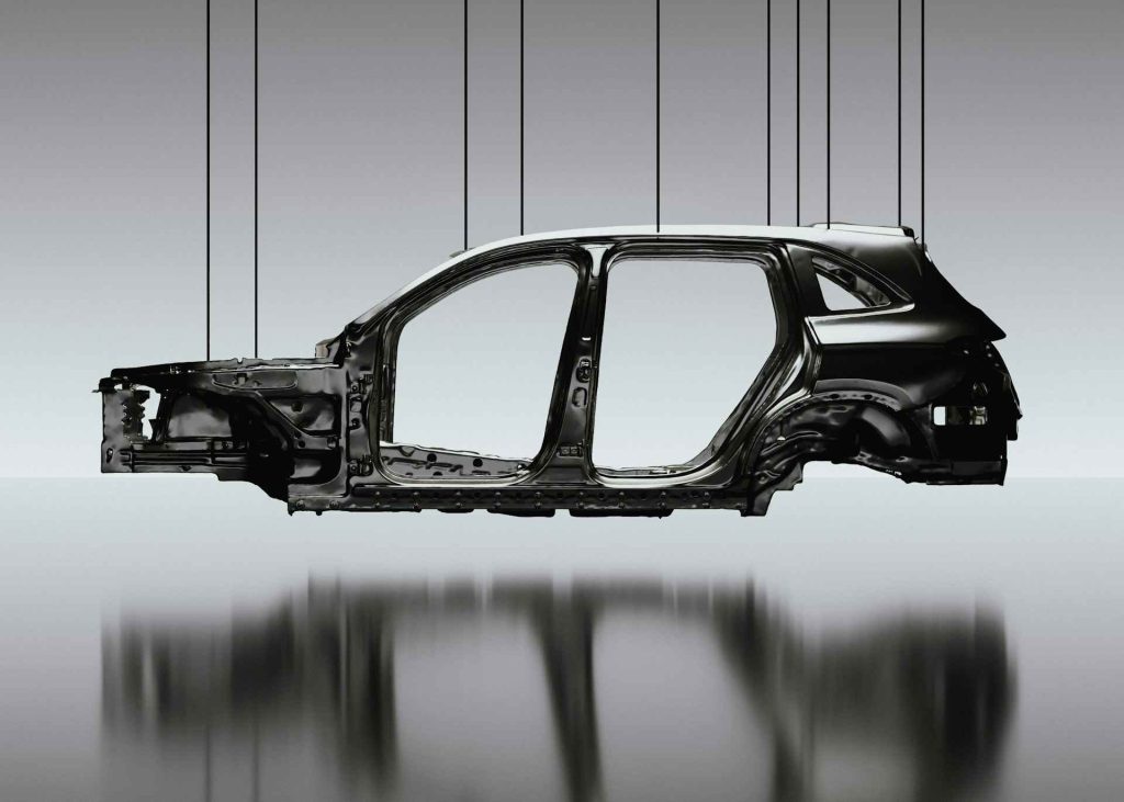 A suspended, black car frame against a gradient background, highlighting its structure with a reflective surface below.